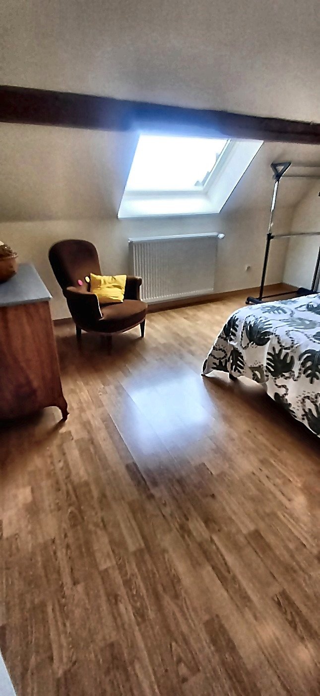 Espace détente avec fauteuil crapaud velours chocolat, vélux et commode